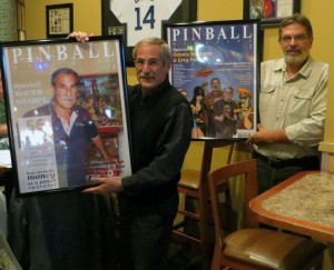 Roger Sharpe (left) and Dennis Nordman with their framed Pinball Magazine cover posters
