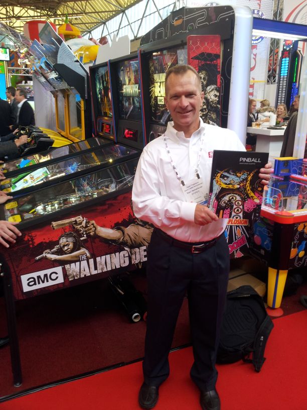 Sternn investor dave Peterson shows Santiago Ciuffo's PINBALL book next to The Walking Dead pinball machine